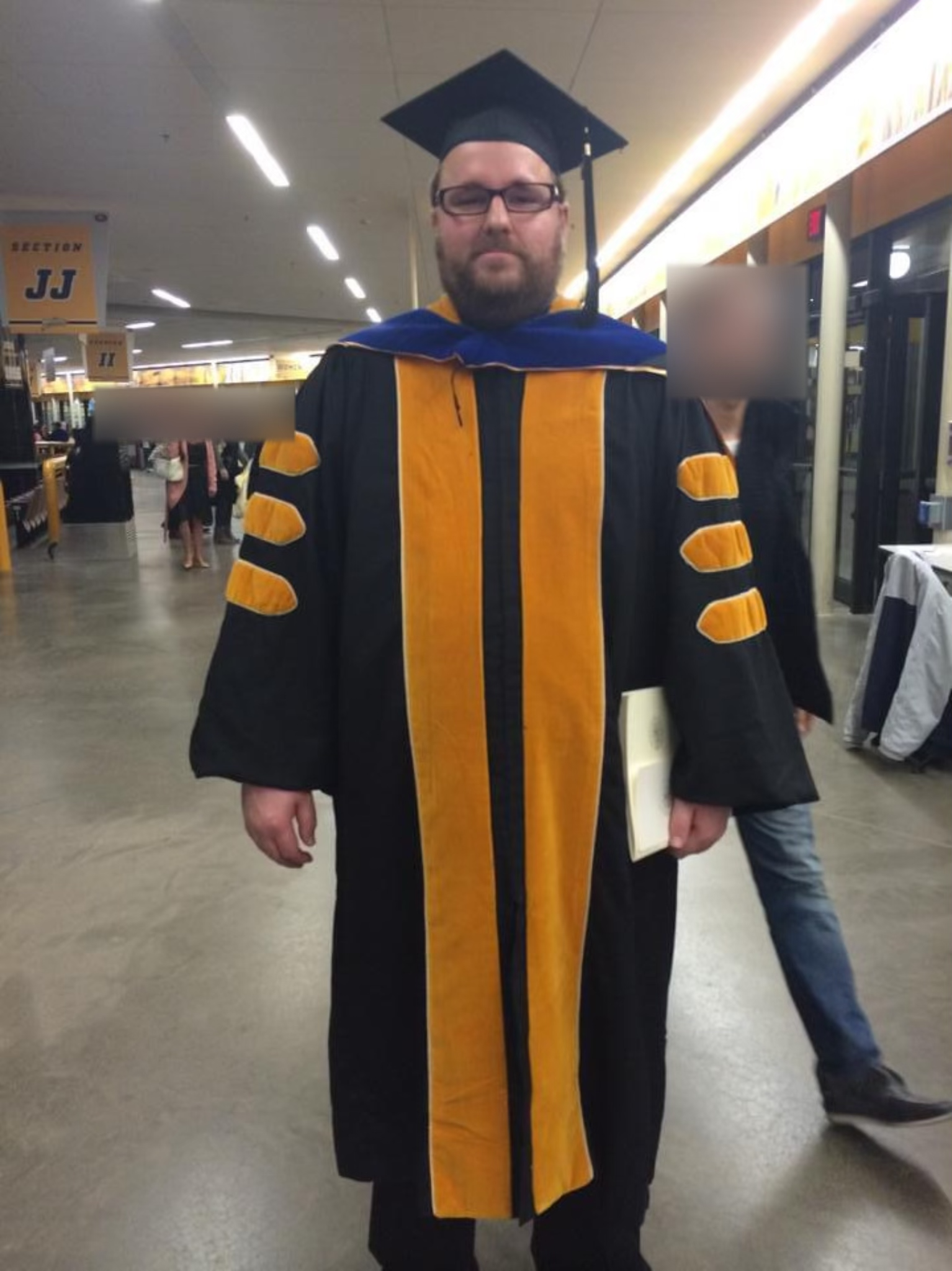 Me posing for a picture during my graduate school graduation ceremony.